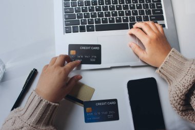 Kapanmış adam dizüstü bilgisayarı kullan kredi kartı kullan cep telefonu kullan kahve dükkanında masaya otur, dinlenme dinlenme dinlenme dinlenme dinlenme boş zamanlarında serbest mobil konsepte odaklan nesneye odaklan