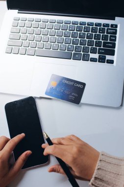 Kapanmış adam dizüstü bilgisayarı kullan kredi kartı kullan cep telefonu kullan kahve dükkanında masaya otur, dinlenme dinlenme dinlenme dinlenme dinlenme boş zamanlarında serbest mobil konsepte odaklan nesneye odaklan