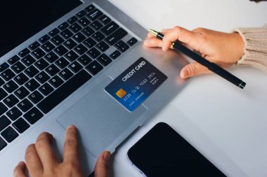 Kapanmış adam dizüstü bilgisayarı kullan kredi kartı kullan cep telefonu kullan kahve dükkanında masaya otur, dinlenme dinlenme dinlenme dinlenme dinlenme boş zamanlarında serbest mobil konsepte odaklan nesneye odaklan