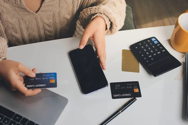 Kapanmış adam dizüstü bilgisayarı kullan kredi kartı kullan cep telefonu kullan kahve dükkanında masaya otur, dinlenme dinlenme dinlenme dinlenme dinlenme boş zamanlarında serbest mobil konsepte odaklan nesneye odaklan