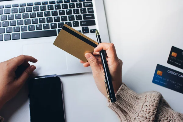 Kapanmış adam dizüstü bilgisayarı kullan kredi kartı kullan cep telefonu kullan kahve dükkanında masaya otur, dinlenme dinlenme dinlenme dinlenme dinlenme boş zamanlarında serbest mobil konsepte odaklan nesneye odaklan