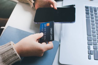 Kapanmış adam dizüstü bilgisayarı kullan kredi kartı kullan cep telefonu kullan kahve dükkanında masaya otur, dinlenme dinlenme dinlenme dinlenme dinlenme boş zamanlarında serbest mobil konsepte odaklan nesneye odaklan