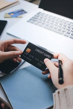 Kapanmış adam dizüstü bilgisayarı kullan kredi kartı kullan cep telefonu kullan kahve dükkanında masaya otur, dinlenme dinlenme dinlenme dinlenme dinlenme boş zamanlarında serbest mobil konsepte odaklan nesneye odaklan