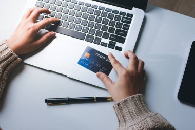 Kapanmış adam dizüstü bilgisayarı kullan kredi kartı kullan cep telefonu kullan kahve dükkanında masaya otur, dinlenme dinlenme dinlenme dinlenme dinlenme boş zamanlarında serbest mobil konsepte odaklan nesneye odaklan