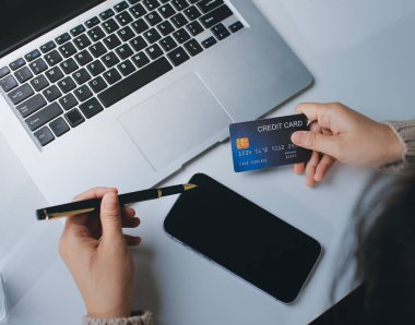 Kapanmış adam dizüstü bilgisayarı kullan kredi kartı kullan cep telefonu kullan kahve dükkanında masaya otur, dinlenme dinlenme dinlenme dinlenme dinlenme boş zamanlarında serbest mobil konsepte odaklan nesneye odaklan