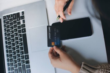 Kapanmış adam dizüstü bilgisayarı kullan kredi kartı kullan cep telefonu kullan kahve dükkanında masaya otur, dinlenme dinlenme dinlenme dinlenme dinlenme boş zamanlarında serbest mobil konsepte odaklan nesneye odaklan