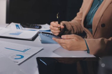 İşadamlarının yakın çekimleri notlar, cep telefonları, çizelgeler, masa, ofis