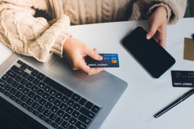 Kapanmış adam dizüstü bilgisayarı kullan kredi kartı kullan cep telefonu kullan kahve dükkanında masaya otur, dinlenme dinlenme dinlenme dinlenme dinlenme boş zamanlarında serbest mobil konsepte odaklan nesneye odaklan