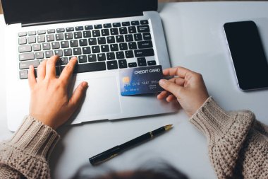 Kapanmış adam dizüstü bilgisayarı kullan kredi kartı kullan cep telefonu kullan kahve dükkanında masaya otur, dinlenme dinlenme dinlenme dinlenme dinlenme boş zamanlarında serbest mobil konsepte odaklan nesneye odaklan