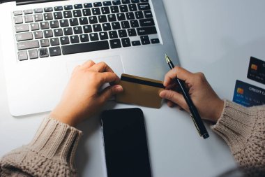 Kapanmış adam dizüstü bilgisayarı kullan kredi kartı kullan cep telefonu kullan kahve dükkanında masaya otur, dinlenme dinlenme dinlenme dinlenme dinlenme boş zamanlarında serbest mobil konsepte odaklan nesneye odaklan