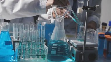 Tıbbi ya da bilimsel araştırmacı ya da insan doktoru laboratuarda bir test tüpü dolusu temiz çözeltiye bakıyor.