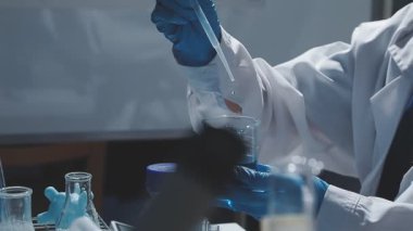 Tıbbi ya da bilimsel araştırmacı ya da insan doktoru laboratuarda bir test tüpü dolusu temiz çözeltiye bakıyor.