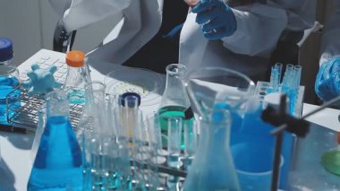 Tıbbi ya da bilimsel araştırmacı ya da insan doktoru laboratuarda bir test tüpü dolusu temiz çözeltiye bakıyor.