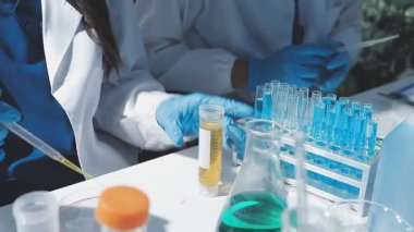 Tıbbi ya da bilimsel araştırmacı ya da insan doktoru laboratuarda bir test tüpü dolusu temiz çözeltiye bakıyor.