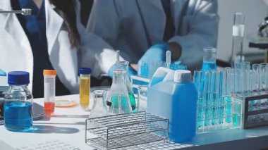 Tıbbi ya da bilimsel araştırmacı ya da insan doktoru laboratuarda bir test tüpü dolusu temiz çözeltiye bakıyor.