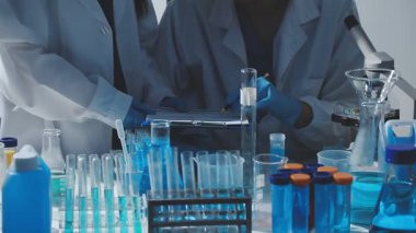 Tıbbi ya da bilimsel araştırmacı ya da insan doktoru laboratuarda bir test tüpü dolusu temiz çözeltiye bakıyor.