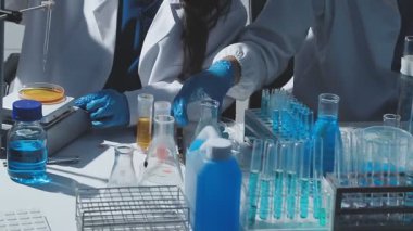 Tıbbi ya da bilimsel araştırmacı ya da insan doktoru laboratuarda bir test tüpü dolusu temiz çözeltiye bakıyor.