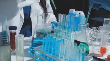 Tıbbi ya da bilimsel araştırmacı ya da insan doktoru laboratuarda bir test tüpü dolusu temiz çözeltiye bakıyor.