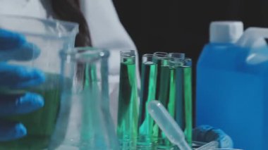 Tıbbi ya da bilimsel araştırmacı ya da insan doktoru laboratuarda bir test tüpü dolusu temiz çözeltiye bakıyor.