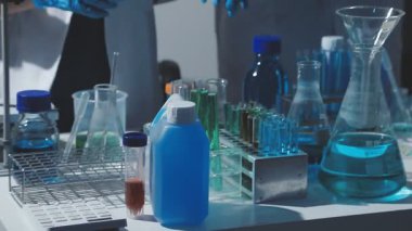 Tıbbi ya da bilimsel araştırmacı ya da insan doktoru laboratuarda bir test tüpü dolusu temiz çözeltiye bakıyor.