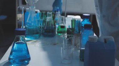 Tıbbi ya da bilimsel araştırmacı ya da insan doktoru laboratuarda bir test tüpü dolusu temiz çözeltiye bakıyor.