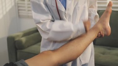 Doktor bir hastaya bacak tedavisi yapıyor.