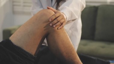 Doktor bir hastaya bacak tedavisi yapıyor.