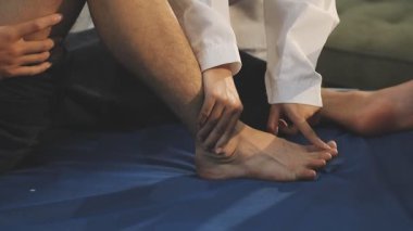 Doktor bir hastaya bacak tedavisi yapıyor.