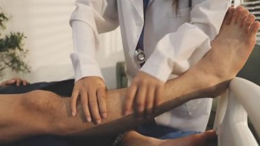 Doktor bir hastaya bacak tedavisi yapıyor.