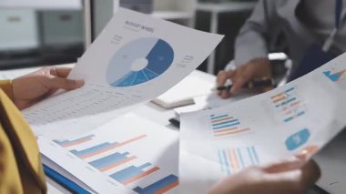 Ofiste çalışan denetçi ve muhasebeci ekibi mali verileri ve muhasebe kayıtlarını hesap makinesiyle analiz ediyor. Muhasebe şirketi kârlı nakit akışı için finansman ve vergilendirme planlaması sağlıyor