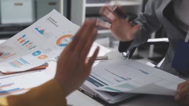 Ofiste çalışan denetçi ve muhasebeci ekibi mali verileri ve muhasebe kayıtlarını hesap makinesiyle analiz ediyor. Muhasebe şirketi kârlı nakit akışı için finansman ve vergilendirme planlaması sağlıyor