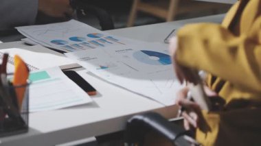 Ofiste çalışan denetçi ve muhasebeci ekibi mali verileri ve muhasebe kayıtlarını hesap makinesiyle analiz ediyor. Muhasebe şirketi kârlı nakit akışı için finansman ve vergilendirme planlaması sağlıyor