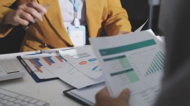 Ofiste çalışan denetçi ve muhasebeci ekibi mali verileri ve muhasebe kayıtlarını hesap makinesiyle analiz ediyor. Muhasebe şirketi kârlı nakit akışı için finansman ve vergilendirme planlaması sağlıyor