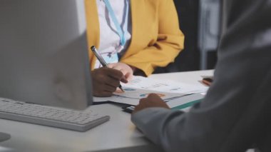 Ofiste çalışan denetçi ve muhasebeci ekibi mali verileri ve muhasebe kayıtlarını hesap makinesiyle analiz ediyor. Muhasebe şirketi kârlı nakit akışı için finansman ve vergilendirme planlaması sağlıyor