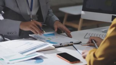 Ofiste çalışan denetçi ve muhasebeci ekibi mali verileri ve muhasebe kayıtlarını hesap makinesiyle analiz ediyor. Muhasebe şirketi kârlı nakit akışı için finansman ve vergilendirme planlaması sağlıyor