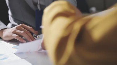 Ofiste çalışan denetçi ve muhasebeci ekibi mali verileri ve muhasebe kayıtlarını hesap makinesiyle analiz ediyor. Muhasebe şirketi kârlı nakit akışı için finansman ve vergilendirme planlaması sağlıyor