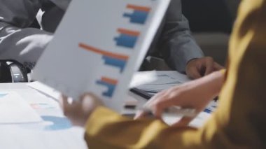 Ofiste çalışan denetçi ve muhasebeci ekibi mali verileri ve muhasebe kayıtlarını hesap makinesiyle analiz ediyor. Muhasebe şirketi kârlı nakit akışı için finansman ve vergilendirme planlaması sağlıyor