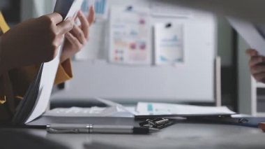 Ofiste çalışan denetçi ve muhasebeci ekibi mali verileri ve muhasebe kayıtlarını hesap makinesiyle analiz ediyor. Muhasebe şirketi kârlı nakit akışı için finansman ve vergilendirme planlaması sağlıyor