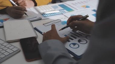 Ofiste çalışan denetçi ve muhasebeci ekibi mali verileri ve muhasebe kayıtlarını hesap makinesiyle analiz ediyor. Muhasebe şirketi kârlı nakit akışı için finansman ve vergilendirme planlaması sağlıyor