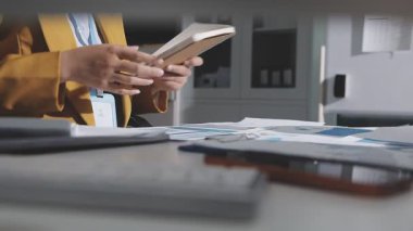 Ofiste çalışan denetçi ve muhasebeci ekibi mali verileri ve muhasebe kayıtlarını hesap makinesiyle analiz ediyor. Muhasebe şirketi kârlı nakit akışı için finansman ve vergilendirme planlaması sağlıyor