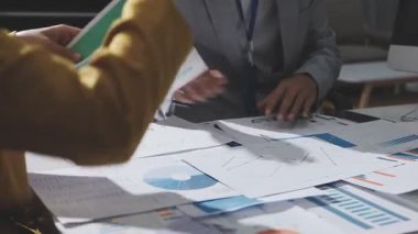 Ofiste çalışan denetçi ve muhasebeci ekibi mali verileri ve muhasebe kayıtlarını hesap makinesiyle analiz ediyor. Muhasebe şirketi kârlı nakit akışı için finansman ve vergilendirme planlaması sağlıyor