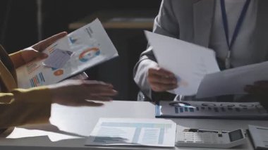 Ofiste çalışan denetçi ve muhasebeci ekibi mali verileri ve muhasebe kayıtlarını hesap makinesiyle analiz ediyor. Muhasebe şirketi kârlı nakit akışı için finansman ve vergilendirme planlaması sağlıyor