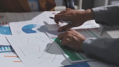 Ofiste çalışan denetçi ve muhasebeci ekibi mali verileri ve muhasebe kayıtlarını hesap makinesiyle analiz ediyor. Muhasebe şirketi kârlı nakit akışı için finansman ve vergilendirme planlaması sağlıyor