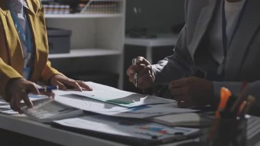 Ofiste çalışan denetçi ve muhasebeci ekibi mali verileri ve muhasebe kayıtlarını hesap makinesiyle analiz ediyor. Muhasebe şirketi kârlı nakit akışı için finansman ve vergilendirme planlaması sağlıyor