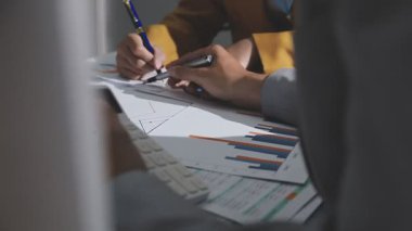 Ofiste çalışan denetçi ve muhasebeci ekibi mali verileri ve muhasebe kayıtlarını hesap makinesiyle analiz ediyor. Muhasebe şirketi kârlı nakit akışı için finansman ve vergilendirme planlaması sağlıyor