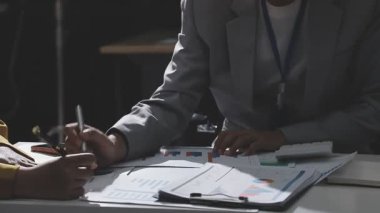 Ofiste çalışan denetçi ve muhasebeci ekibi mali verileri ve muhasebe kayıtlarını hesap makinesiyle analiz ediyor. Muhasebe şirketi kârlı nakit akışı için finansman ve vergilendirme planlaması sağlıyor