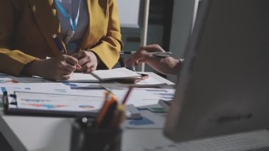 Ofiste çalışan denetçi ve muhasebeci ekibi mali verileri ve muhasebe kayıtlarını hesap makinesiyle analiz ediyor. Muhasebe şirketi kârlı nakit akışı için finansman ve vergilendirme planlaması sağlıyor