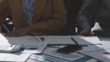 Ofiste çalışan denetçi ve muhasebeci ekibi mali verileri ve muhasebe kayıtlarını hesap makinesiyle analiz ediyor. Muhasebe şirketi kârlı nakit akışı için finansman ve vergilendirme planlaması sağlıyor