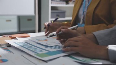 Ofiste çalışan denetçi ve muhasebeci ekibi mali verileri ve muhasebe kayıtlarını hesap makinesiyle analiz ediyor. Muhasebe şirketi kârlı nakit akışı için finansman ve vergilendirme planlaması sağlıyor