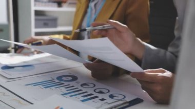 Ofiste çalışan denetçi ve muhasebeci ekibi mali verileri ve muhasebe kayıtlarını hesap makinesiyle analiz ediyor. Muhasebe şirketi kârlı nakit akışı için finansman ve vergilendirme planlaması sağlıyor